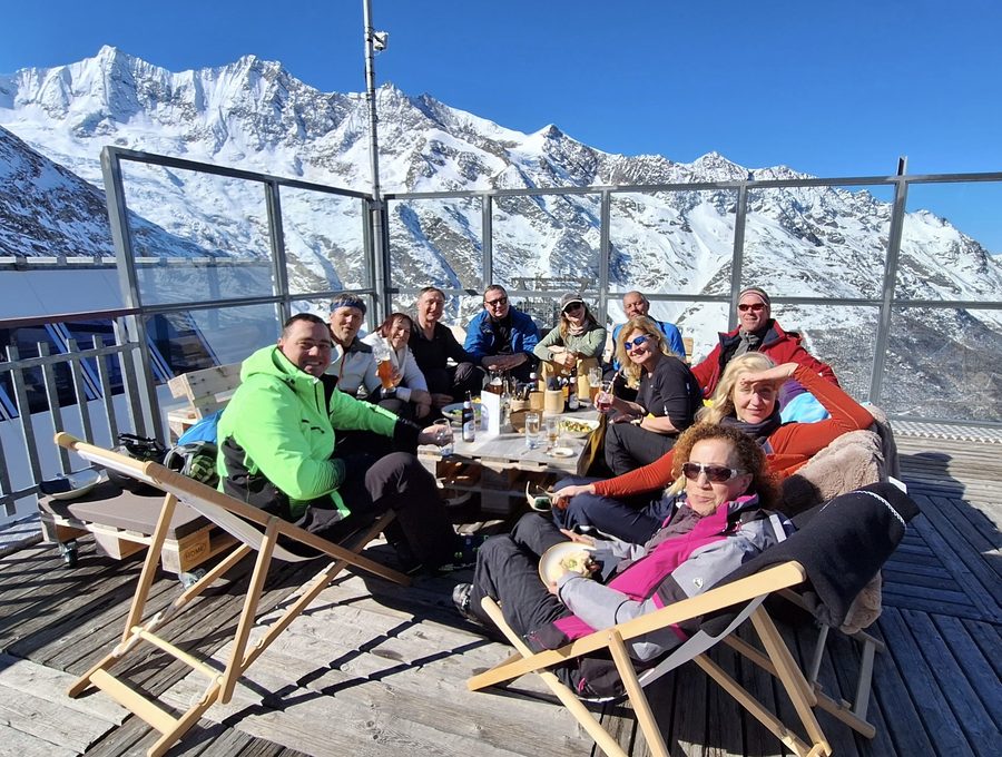 Gruppe auf einer Sonnenterrasse mit Schneebergen